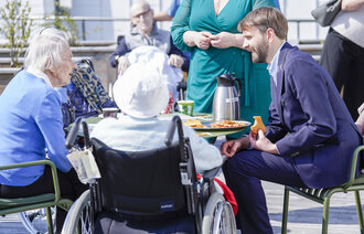 Bildet viser helse- og omsorgsminister Jan Christian Vestre sammen med beboere på Lambertseterhjemmet i Oslo