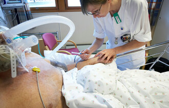 Sykepleier setter sprøyte på pasient, intensivavdelingen på Moss sykehus.