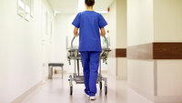 Ansatt triller vogn ned en sykehuskorridor