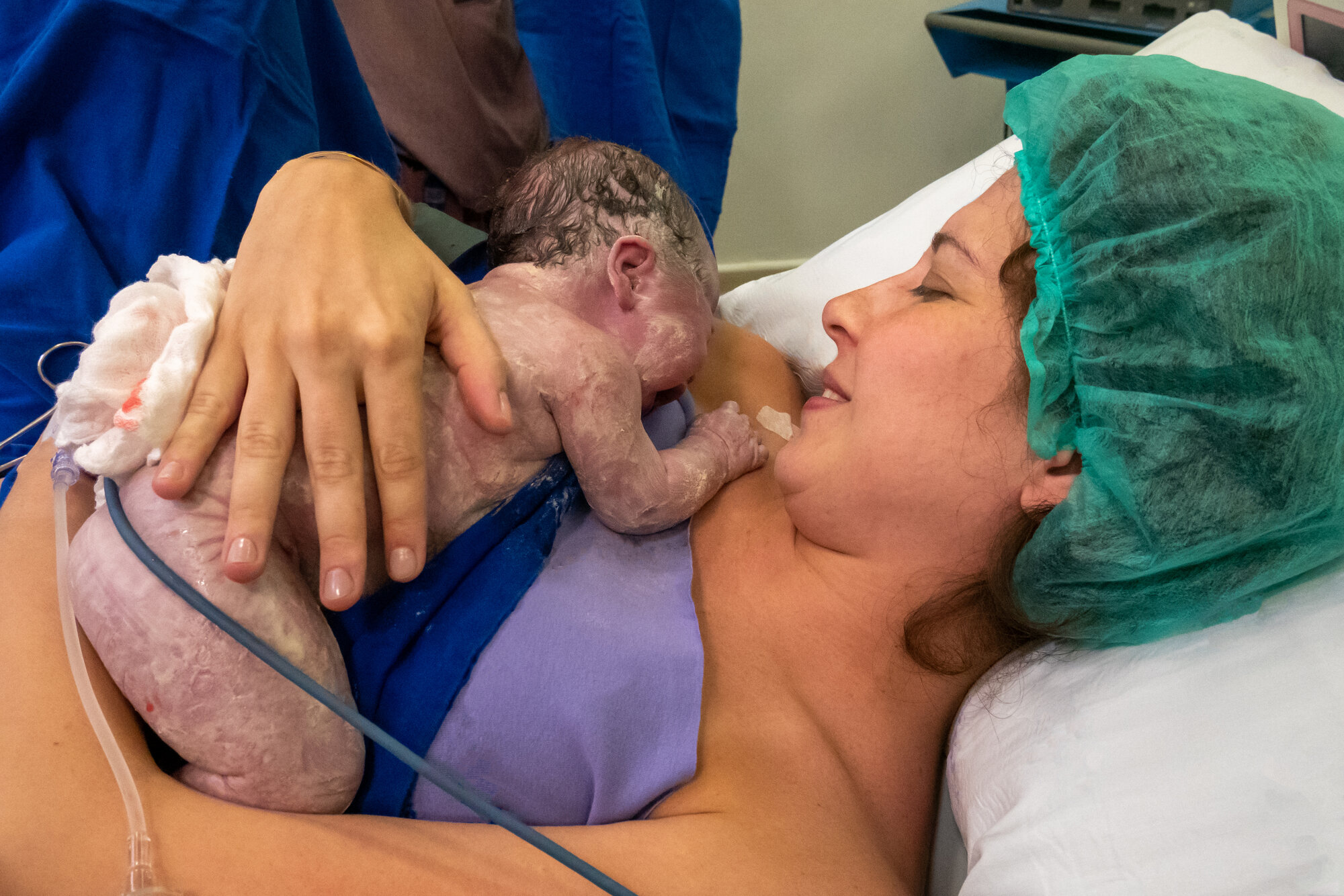 Bildet viser en nyfødt baby som ligger på brystet til moren