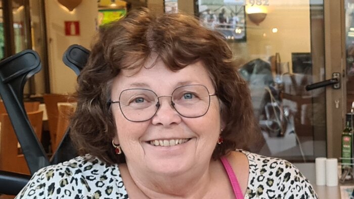 Portrett av en dame som smiler til kameraet.