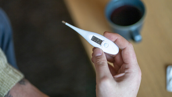 Bildet viser en person som holder et termometer