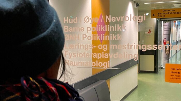 Bilde av sykepleier foran inngangen til Harstad sykehus