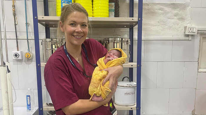 Bildet viser jordmor Martine Topaas Billington med et nyfødt barn i India