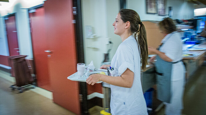 Bildet viser sykepleier i sykehuskorridor