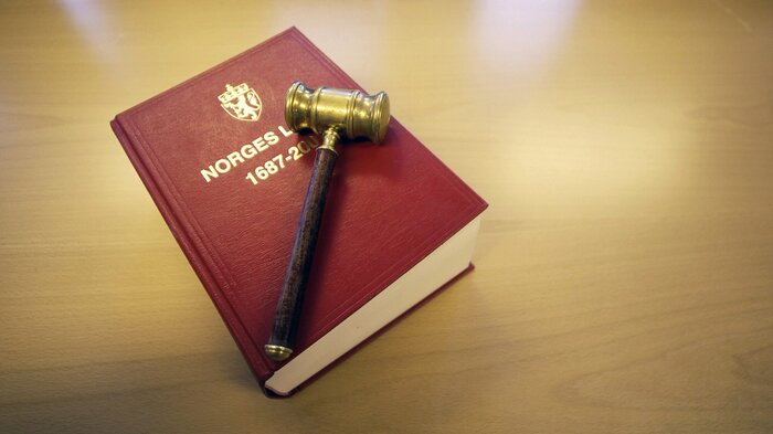 Bildet viser en klubbe som ligger oppå Norges lover