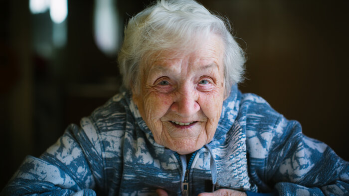 Bildet viser en eldre, smilende kvinne