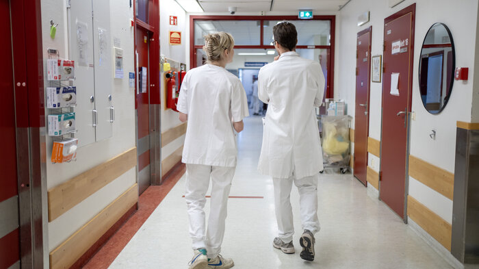 Bildet viser helsepersonell som går i en gang.