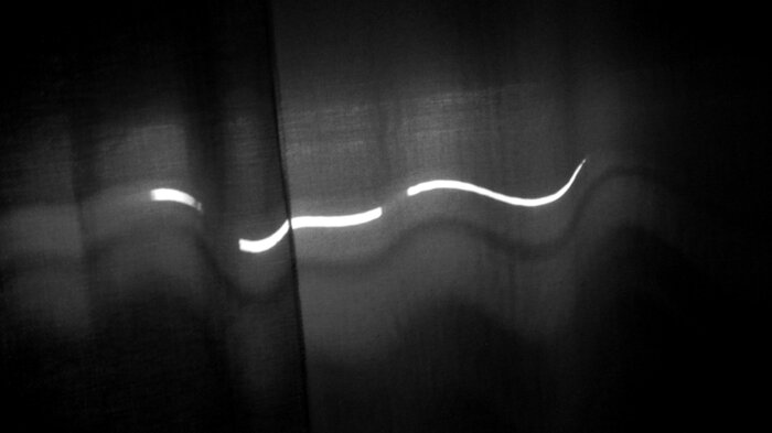 Bildet viser lys utenfra som slipper gjennom soveromsgardiner.