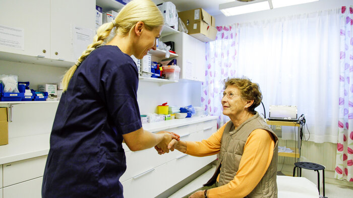 Bildet viser en sykepleier som er med en pasient.