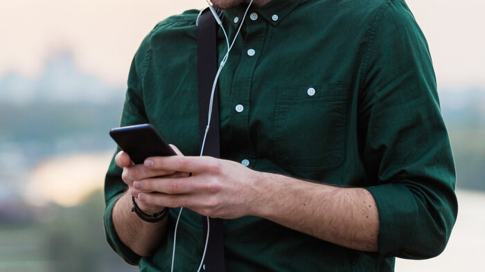 Bildet viser en mann som leser på mobilen.