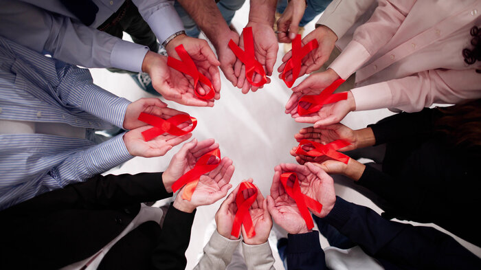 hender som holder røde sløyfer bildet viser hender som holder røde sløyfer