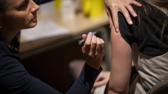 Bildet viser helsepersonell som gir en sprøyte med influensavaksine.