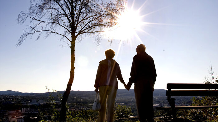 Bildet viser skyggene av to eldre mennesker som holder hender.