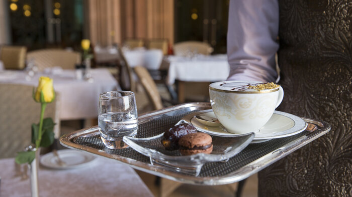 Bildet viser en servitør som serverer kaffe.