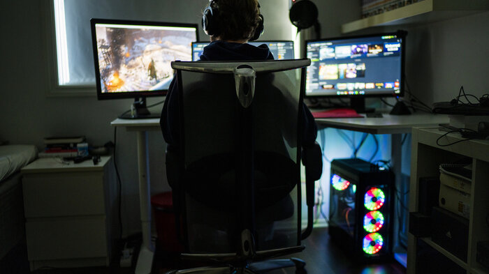 Bildet viser en gutt som gamer alene på gutterommet.