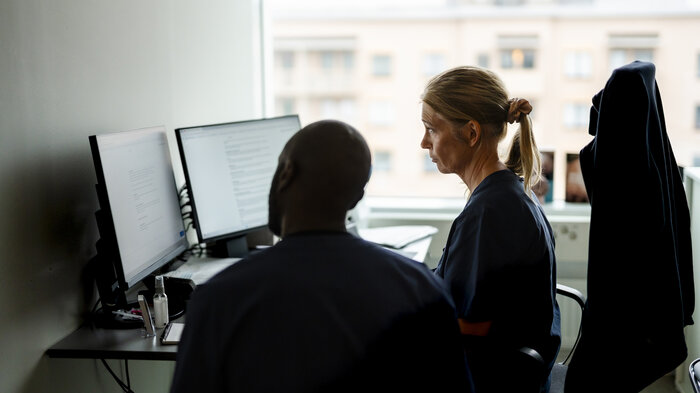 Bildet viser en lege som ser på en PC-skjerm.