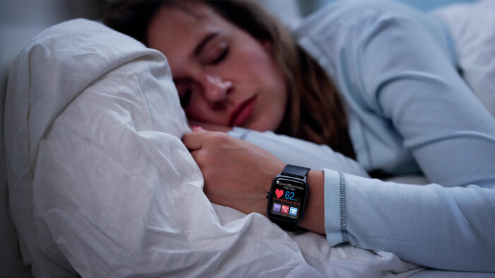 Bildet viser en kvinne som sover med smartklokke.