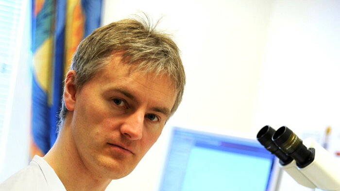 Bildet viser Sveinung Wergeland Sørbye ved mikroskopet.