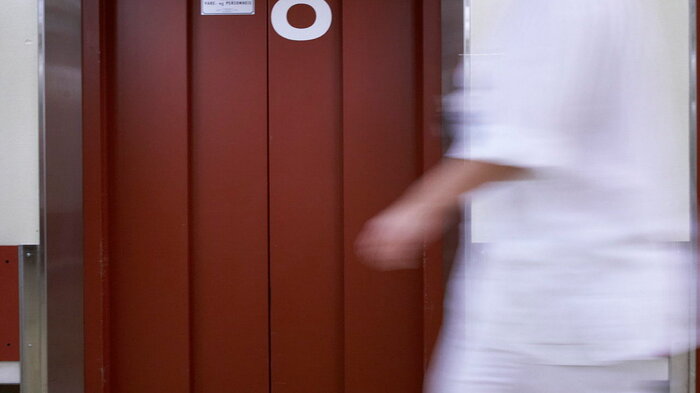 Bildet viser en sykepleier som beveger seg raskt i en korridor Bildet viser en sykepleier som beveger seg raskt i en korridor