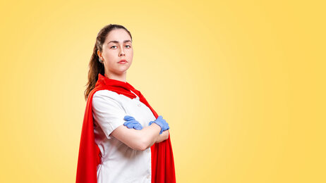 Bildet viser en overlegen sykepleier med rød kappe rundt skuldrene