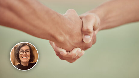 Bildet viser to mennesker som gir hverandre et håndtrykk