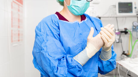 Bildet viser en sykepleier i fullt smittevernutstyr