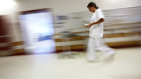 Bildet viser en sykepleier på sykehus som løper og stresser