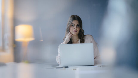 Bildet viser en ung kvinne som jobber på en datamaskin
