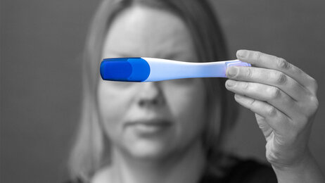 Bildet viser en kvinne som holder opp en graviditetstest.