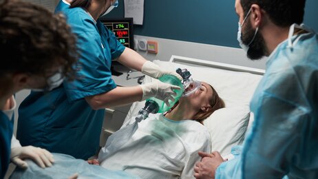 Bildet viser en traumepasient som f&aring;r ventilasjon av en sykepleier i traumeteamet. Rundt sengen st&aring;r flere sykepleiere