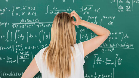 Student som står foran en tavle med matematiske formler