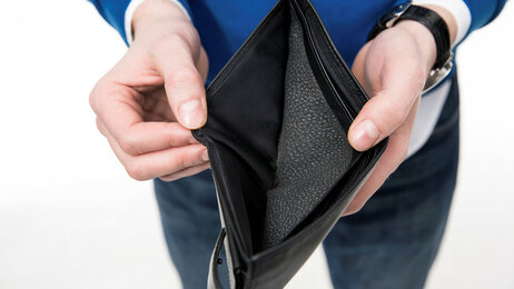 Bildet viser en person som holder frem en tom lommebok