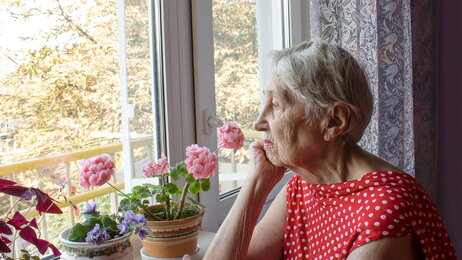Eldre dame kikker ut av vindu