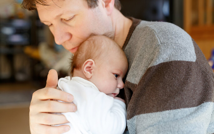 Bildet viser en far og en nyfødt baby