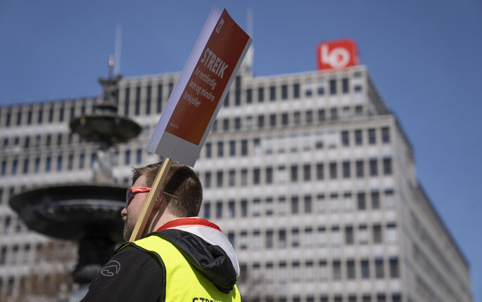 Bildet viser streikende mann med gul vest og plakat