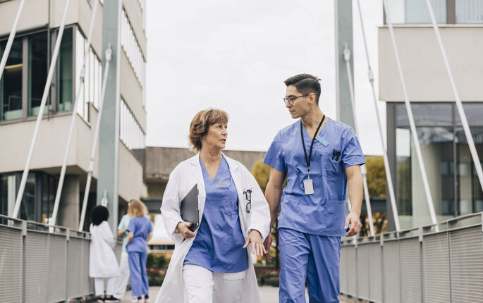 Lege og sykepleier i diskusjon Bildet viser lege og sykepleier i diskusjon