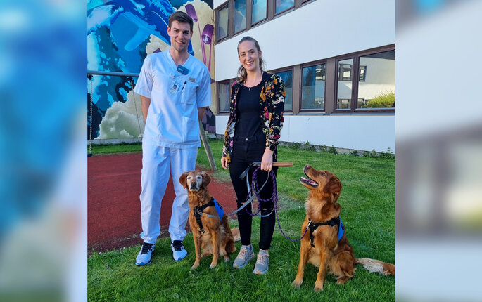 Bildet viser Susanne Rueness Espeseth og barnesykepleier Aleksander Hayes Sundby med terapihundene Aiva og Karma