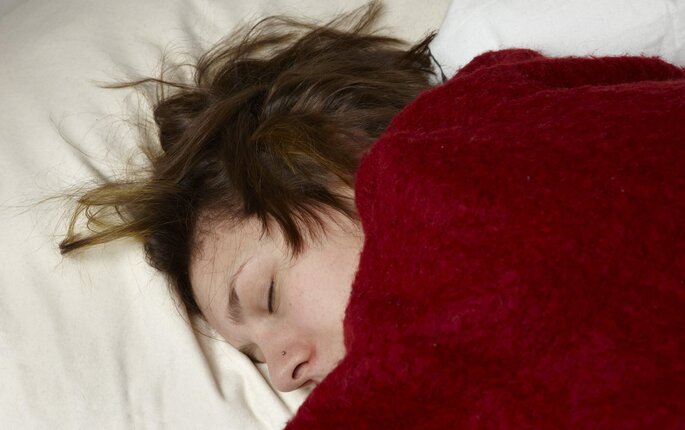 Bildet viser en syk kvinne som ligger i sengen