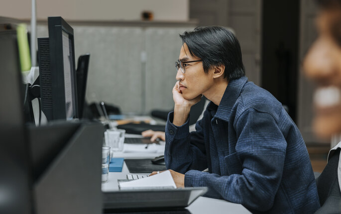 Bildet viser en person som jobber på PC.