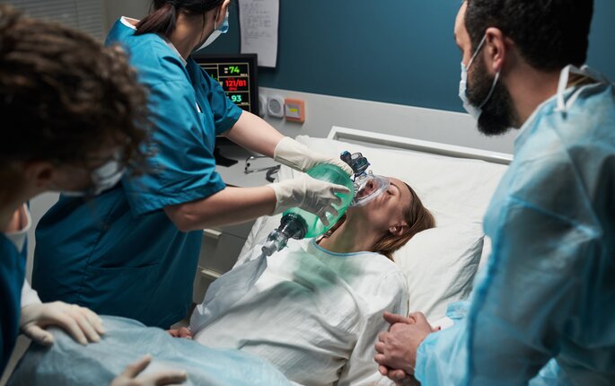 Bildet viser en traumepasient som får ventilasjon av en sykepleier i traumeteamet. Rundt sengen står flere sykepleiere