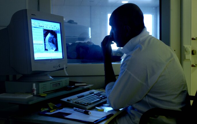 Bildet viser en radiolog som ser på røntgen Bildet viser en radiolog som ser på røntgen