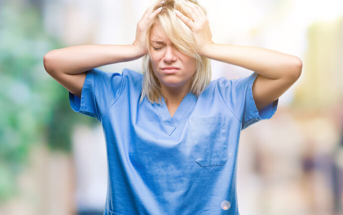 Bildet viser en sykepleier som er stresset og fortvilet