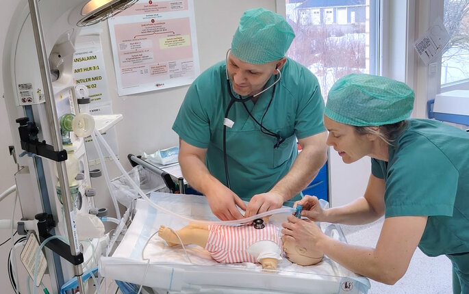 Bildet viser to anestesisykepleiere som simulerer på en babydukke
