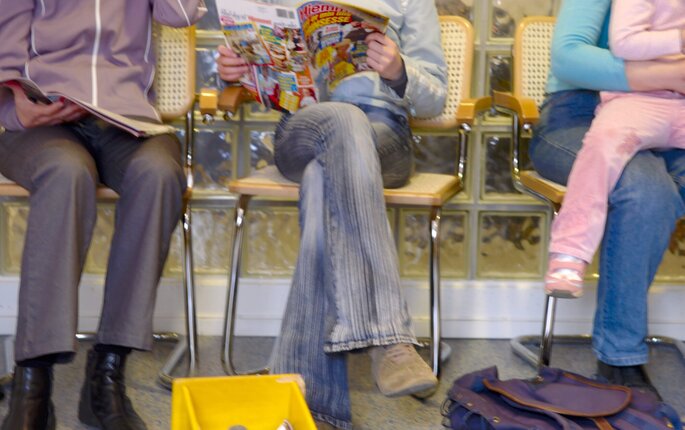 Bildet viser bena til pasienter som sitter på venterom