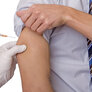 Bildet viser en person som får en medisinsk sprøyte i armen