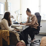 Bildet viser en helsesykepleier som prater med en elev på et kontor