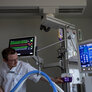 Bildet viser en sykepleier som gjør klart apparat for enteral ernæring på intensiven