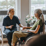 Bildet viser en sykepleier som er hjemme hos en palliativ pasient