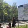 Bildet viser en dame som står foran et digert skilt foran St. Olavs hospital. Skiltet viser informasjon om sykehuset